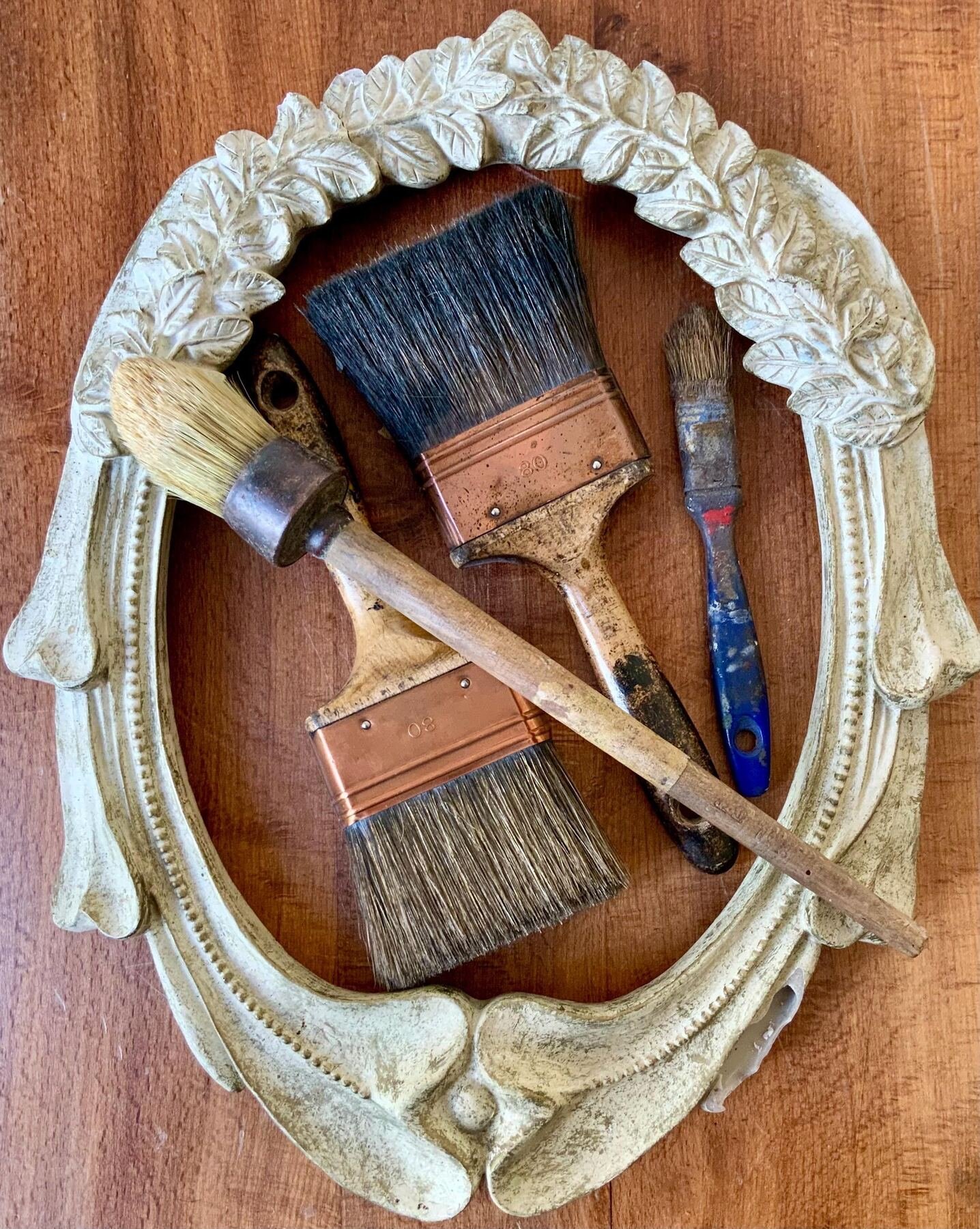 Decorator's paintbrushes and tools resting on a period wooden surface